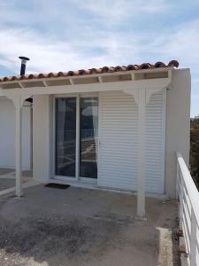 a white house with a window and a roof at Cute&Quiet Studio Loutraki in Loutraki