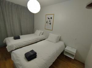 two beds in a small room with a lamp at MajoitusYkk&ouml;nen in Raahe