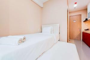 タンゲランにあるNice and Simply Look Studio Apartment at B Residence By Travelioのキッチン付きの客室内の白いベッド2台 +12枚の写真