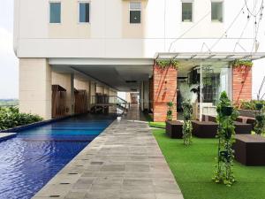 タンゲランにあるNice and Simply Look Studio Apartment at B Residence By Travelioの建物の前にプールがある建物