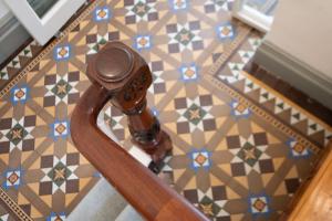 a wooden rail on a staircase with a tile floor at The Stella Historic Llandudno Bed & Breakfast in Llandudno