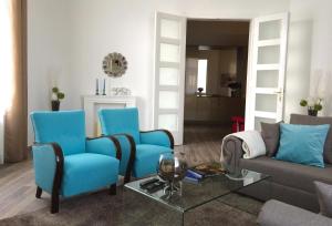 a living room with blue chairs and a couch at Hello Downtown Apartment - Eiffel in Budapest