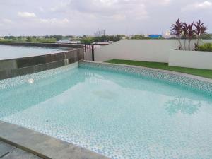 a swimming pool on the roof of a building at Fancy and Elegant Studio at Patraland Urbano Apartment By Travelio in Bekasi