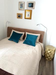 a bedroom with a bed with blue pillows at Hello Downtown Apartment - Eiffel in Budapest