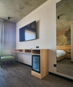 a living room with a tv and a bed at Black Sea Resort in Primorskoye