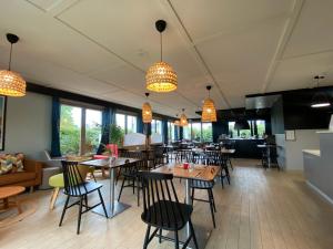a dining room with tables and chairs and lights at Brit Hotel Quimper Sud Climatisé in Quimper