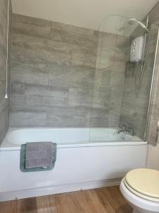 a bathroom with a bath tub and a toilet at Hele Bay Cottage in Ilfracombe +47 photos