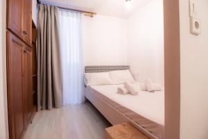 a bedroom with a bed with white sheets and pillows at Modern City Apt in the Heart of Heraklion in Heraklio Town