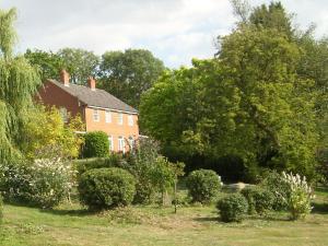 a house with a garden in front of it at The Hall Farm Bed And Breakfast in Tilbrook +7 photos