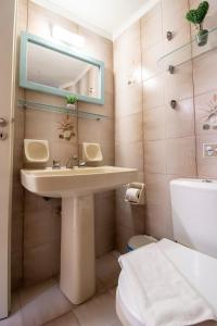 a bathroom with a sink and a toilet and a mirror at Modern City Apt in the Heart of Heraklion in Heraklio Town +16 photos