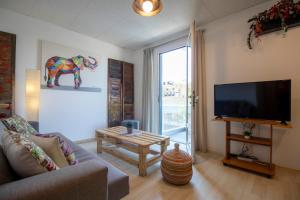 a living room with a couch and a flat screen tv at Modern City Apt in the Heart of Heraklion in Heraklio Town