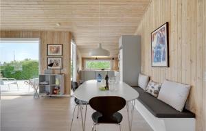 a kitchen and living room with a white table and chairs at Three-Bedroom Holiday Home In Bjert in Binderup Strand