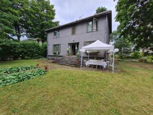 a house with a table and a tent in the yard at Old villa Kaprice Baltic Beach in Jūrmala