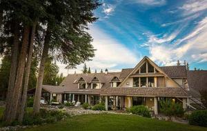 a large house with a gambrel roof at Retreat Wilderness Inn in Nimpo Lake