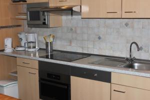 une cuisine avec un évier et une cuisinière four supérieur dans l'établissement Ferienhaus "Buurtweg 219" mit Schwimmbad, à Stavenisse