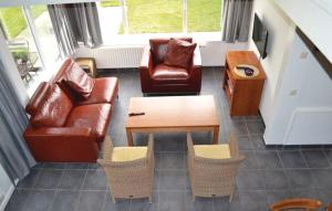 un salon avec un canapé, des chaises et une table dans l'établissement Ferienhaus "Buurtweg 219" mit Schwimmbad, à Stavenisse