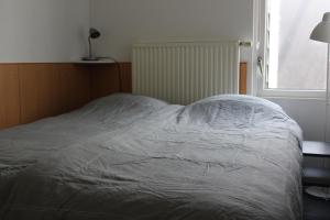 - un lit avec une couette blanche dans une chambre dans l'établissement Ferienhaus "Buurtweg 219" mit Schwimmbad, à Stavenisse 14 autres photos