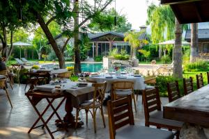 a restaurant with tables and chairs and a pool at Kaya Villas Exclusive in Kayakoy