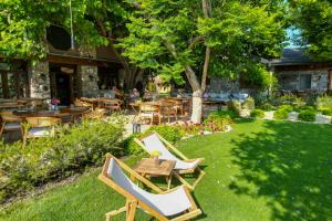 a garden with tables and chairs and a table and chairs at Kaya Villas Exclusive in Kayakoy