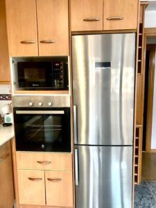 a kitchen with a stainless steel refrigerator and a microwave at NUEVO Con piscina a 2 minutos estación tren AVE in Zaragoza