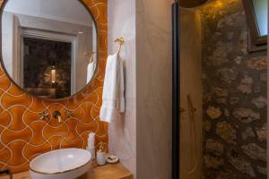 a bathroom with a sink and a mirror at Kaya Villas Exclusive in Kayakoy