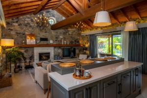 a kitchen and living room with a stone wall at Kaya Villas Exclusive in Kayakoy