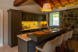a kitchen with a large island with chairs around it at Kaya Villas Exclusive in Kayakoy