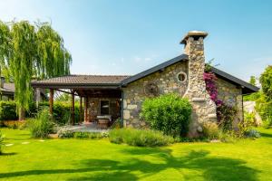 a stone house with a stone chimney in a yard at Kaya Villas Exclusive in Kayakoy