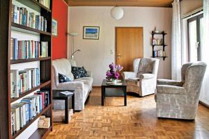 - un salon avec des canapés, des chaises et des étagères dans l'établissement Tolles Ferienhaus in Burhave mit Terrasse und Grill, à Butjadingen