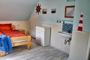 une petite chambre avec un lit et un lavabo dans l'établissement Tolles Ferienhaus in Burhave mit Terrasse und Grill, à Butjadingen