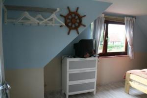 une chambre avec un plafond bleu et une pièce avec une télévision dans l'établissement Tolles Ferienhaus in Burhave mit Terrasse und Grill, à Butjadingen 6 autres photos
