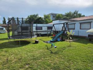 Un patio con columpios y zona de juegos en Melanie apartman 2, en Veľký Meder