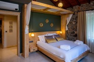 a bedroom with a large bed with a wooden headboard at Kaya Villas Exclusive in Kayakoy