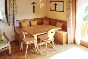 a dining room with a wooden table and chairs at Small holiday cottage Ivy in Schuttertal +3 photos