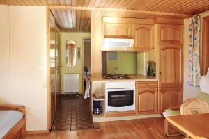 a kitchen with wooden cabinets and a sink at Small holiday cottage Ivy in Schuttertal