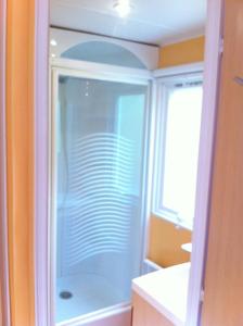 ein Badezimmer mit Dusche mit Glastür in der Unterkunft Mobilheim für 5 Personen ca 29 m in Baarland, Zeeland Küste von Zeeland in Baarland
