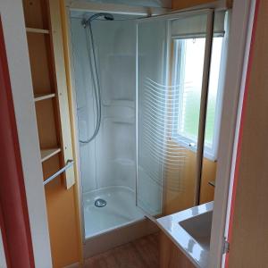 eine Dusche mit Glastür im Badezimmer in der Unterkunft Mobilheim für 5 Personen ca 29 m in Baarland, Zeeland Küste von Zeeland in Baarland + 11 Fotos