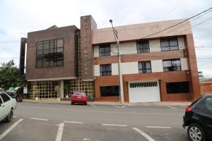 a building on a street with cars parked in front of it at Hotel São Mateus in São Mateus do Sul