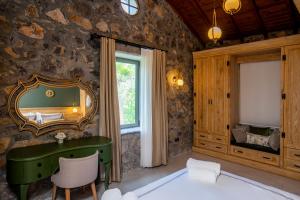 a bedroom with a green desk and a mirror at Kaya Villas Exclusive in Kayakoy