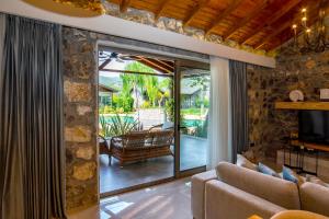 a living room with a couch and a sliding glass door at Kaya Villas Exclusive in Kayakoy