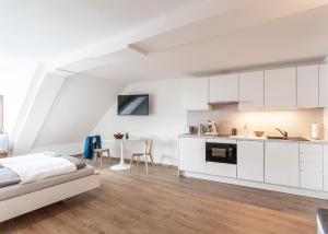 a white kitchen with a bed in a room at Ferienwohnungen SEEELF - Luv Stay in Überlingen