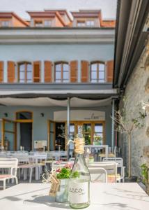 a bottle on a table in front of a building at Ferienwohnungen SEEELF - Luv Stay in Überlingen