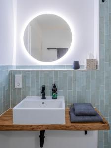 a bathroom with a white sink and a mirror at Ferienwohnungen SEEELF - Luv Stay in Überlingen +42 photos