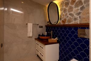 a bathroom with a sink and a mirror at Kaya Villas Exclusive in Kayakoy