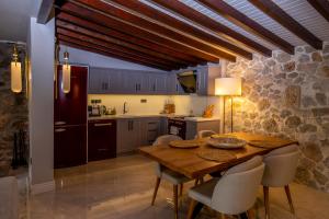 a kitchen with a wooden table and some chairs at Kaya Villas Exclusive in Kayakoy