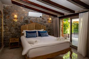 a bedroom with a large white bed with blue pillows at Kaya Villas Exclusive in Kayakoy