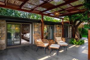 a patio with wicker chairs and a pergola at Kaya Villas Exclusive in Kayakoy