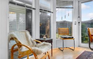 a screened in porch with two chairs and a table at Holiday Home Ydunvej Ebeltoft in Ebeltoft