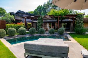 a backyard with a pool and a house with an umbrella at Kaya Villas Exclusive in Kayakoy