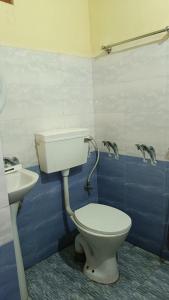 a bathroom with a toilet and a sink at GB Guest House By ROH in Guwahati